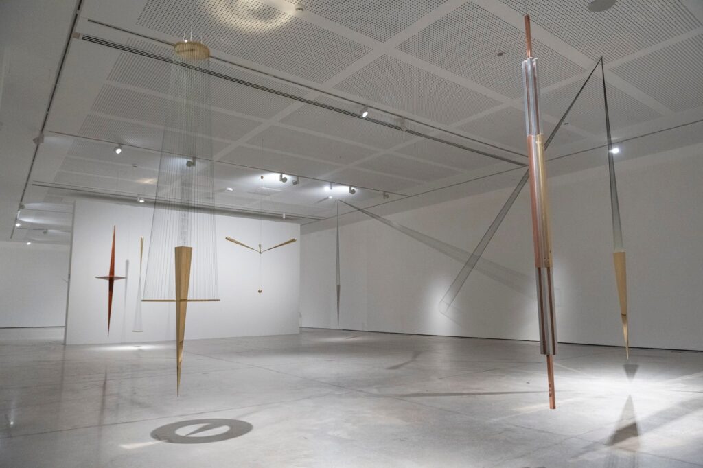 Esculturas metálicas suspendidas de Artur Lescher en una sala blanca del MACA