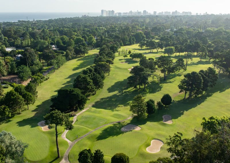 Vista aérea del campo de golf del Cantegril Country Club con Punta del Este al fondo