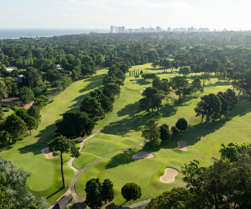 Vista aérea del campo de golf del Cantegril Country Club con Punta del Este al fondo