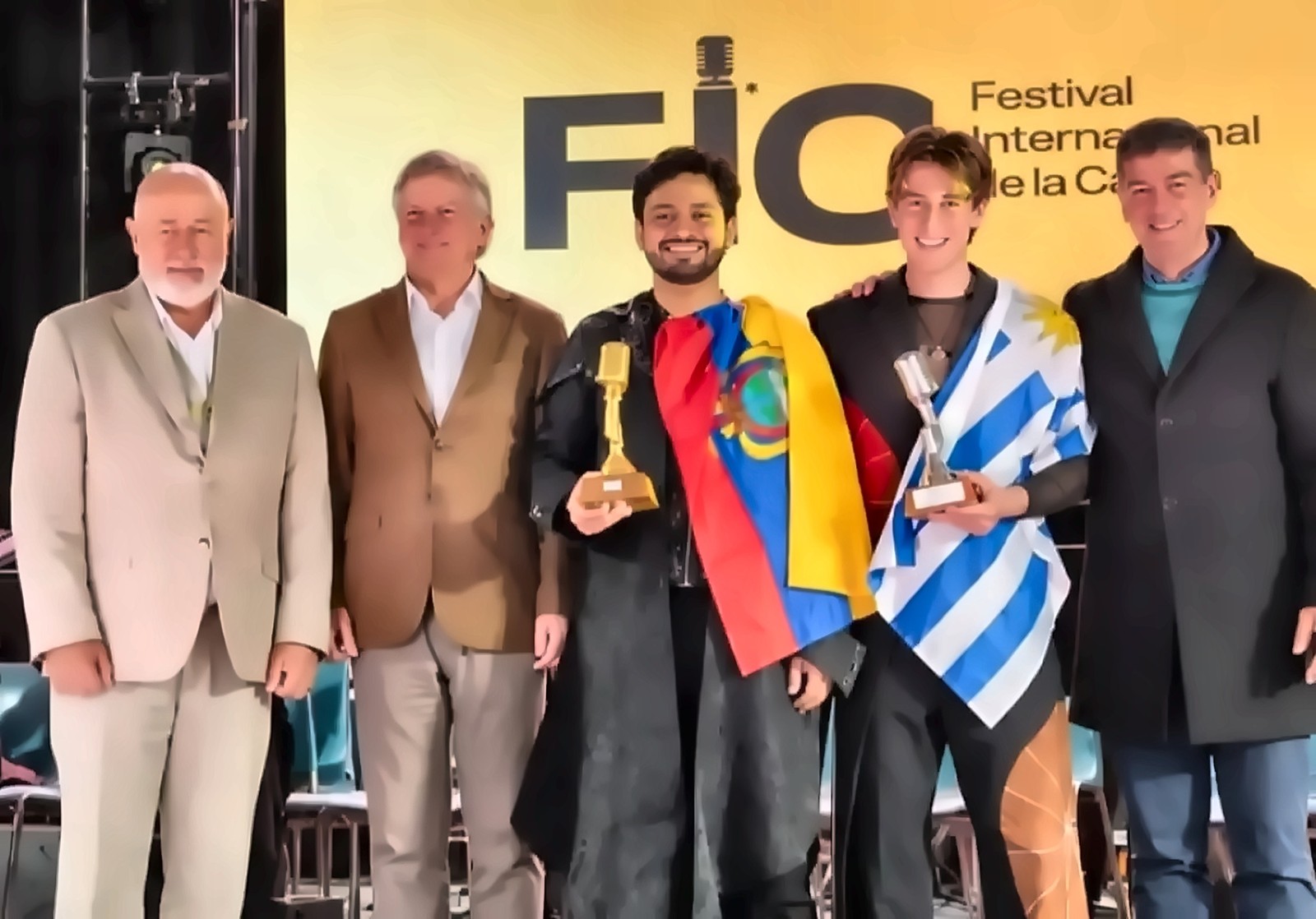 Antonio GF, con la bandera de Ecuador y el trofeo, junto a autoridades y otros premiados