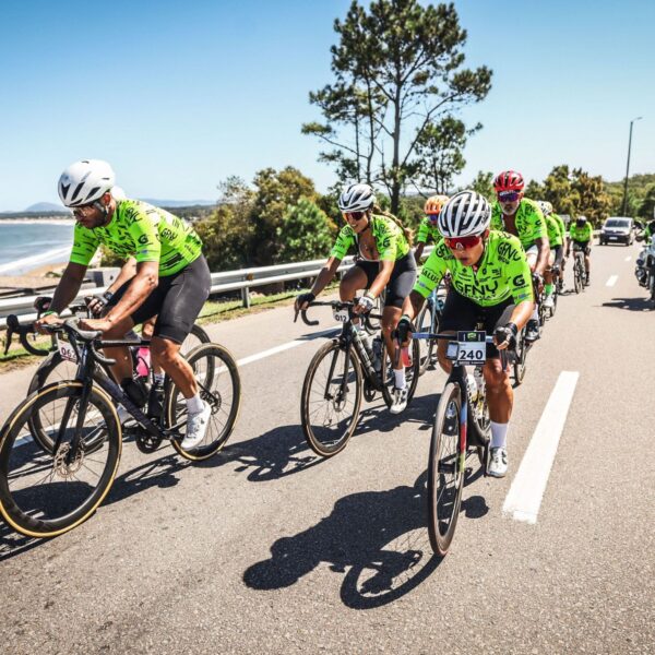Pelotón de ciclistas del GFNY Punta del Este rodando junto al mar en un día soleado