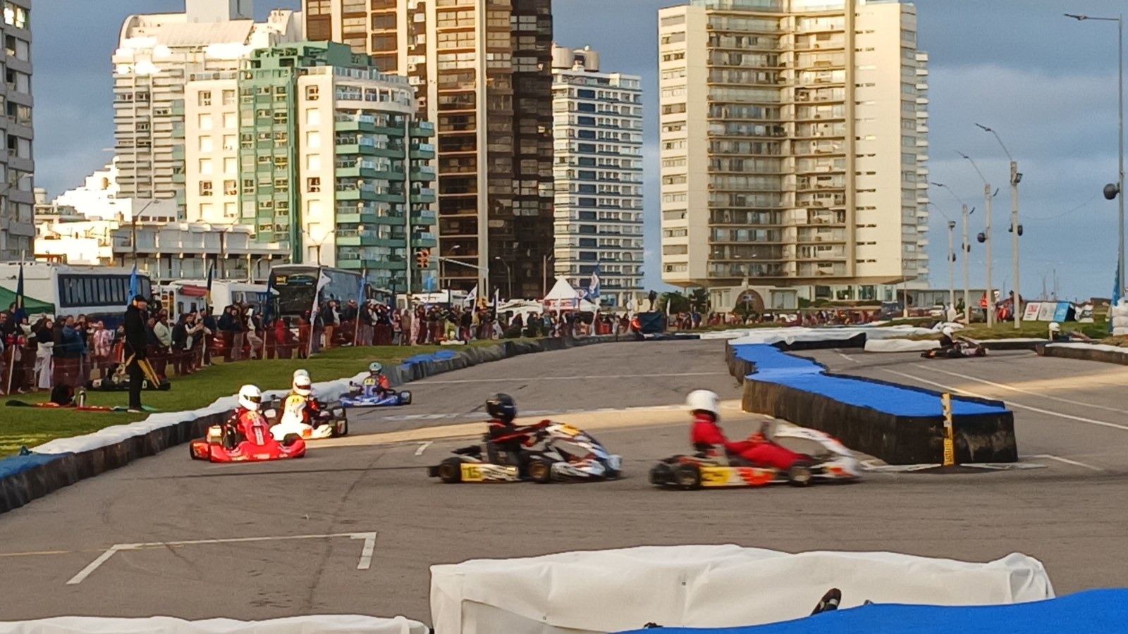 Karts en plena carrera sobre el circuito callejero de la rambla de Punta del Este, con edificios de fondo