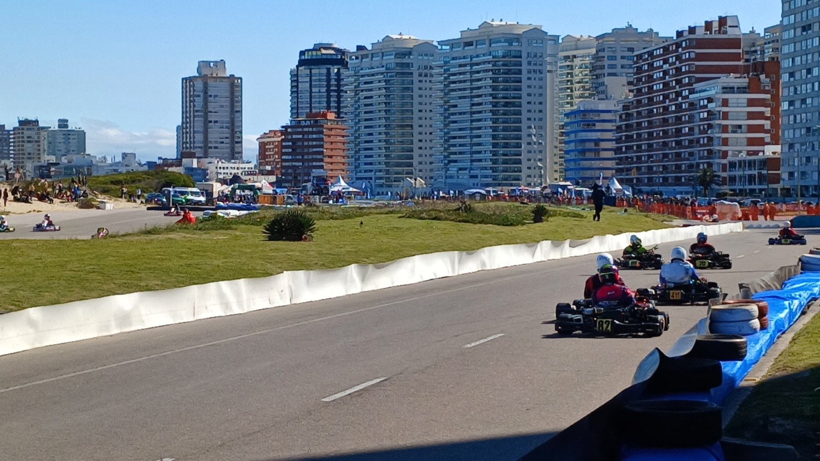 Pilotos de karting recorren una curva del circuito frente a los edificios de la Brava