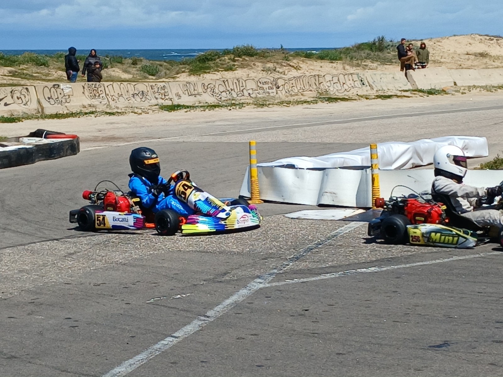 Dos pilotos de karting disputan una posición en el circuito de Punta del Este