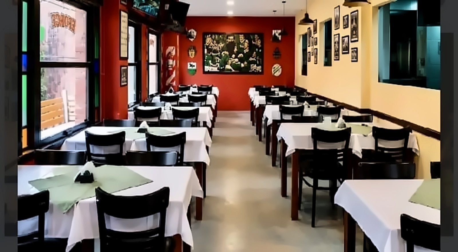 Salón de Lisboa Cantina, con mesas de manteles blancos y paredes con fotos históricas