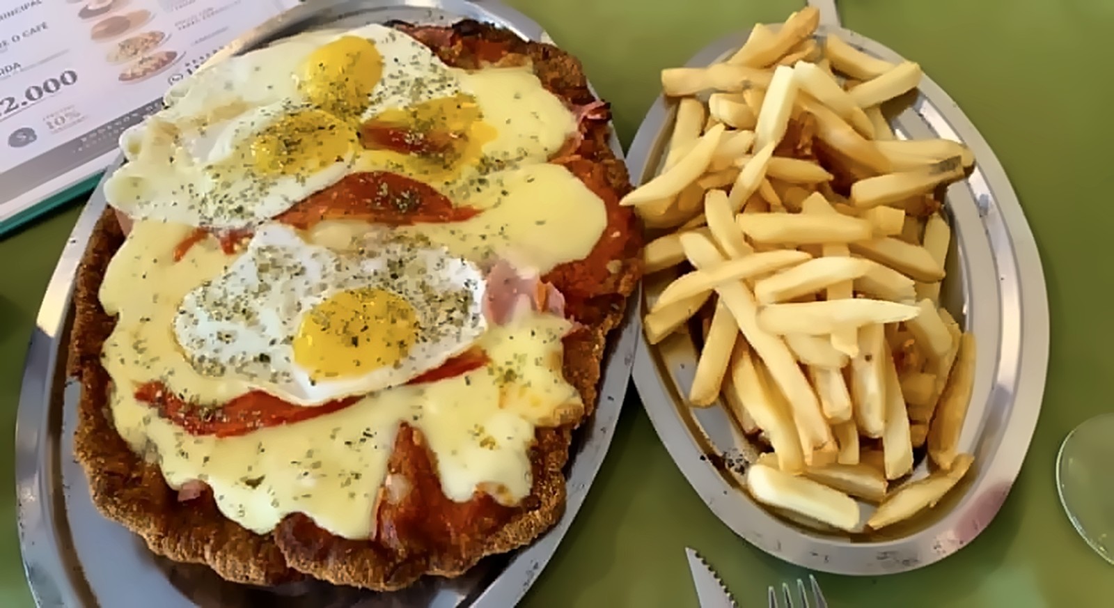 Milanesa napolitana con huevos fritos y papas fritas en Lisboa Cantina