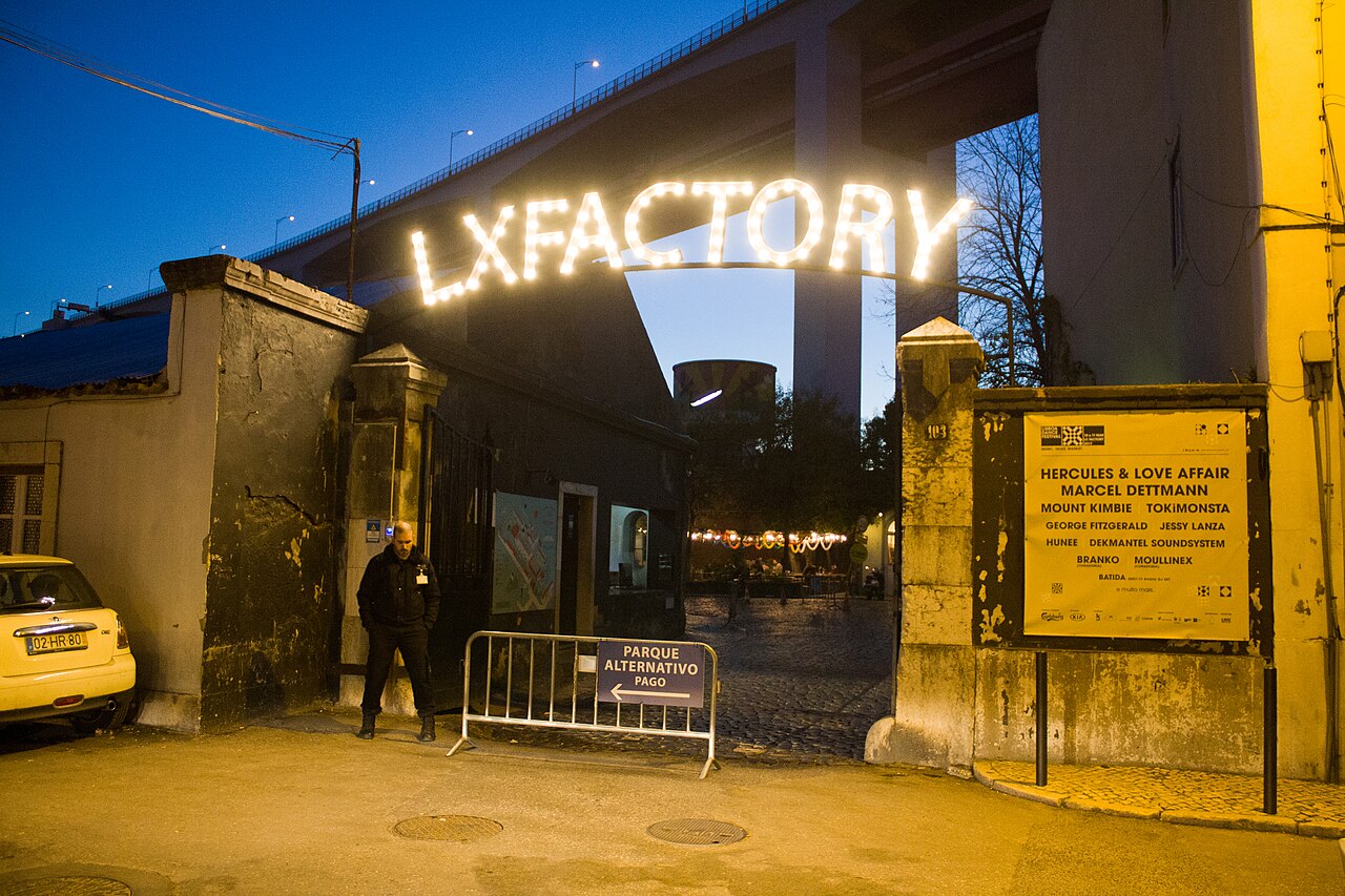 Entrada iluminada de LX Factory en Alcântara al anochecer