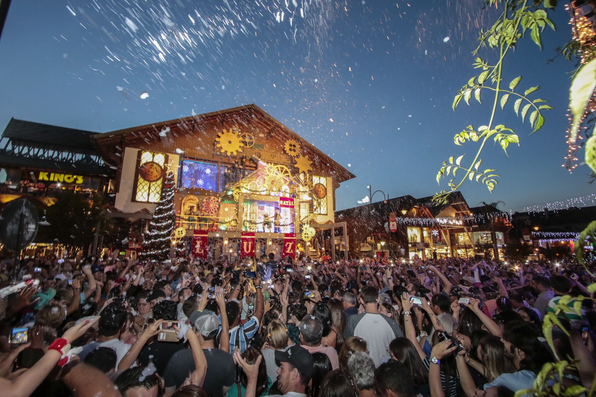 Edificio iluminado con luces navideñas y multitud de público en Gramado