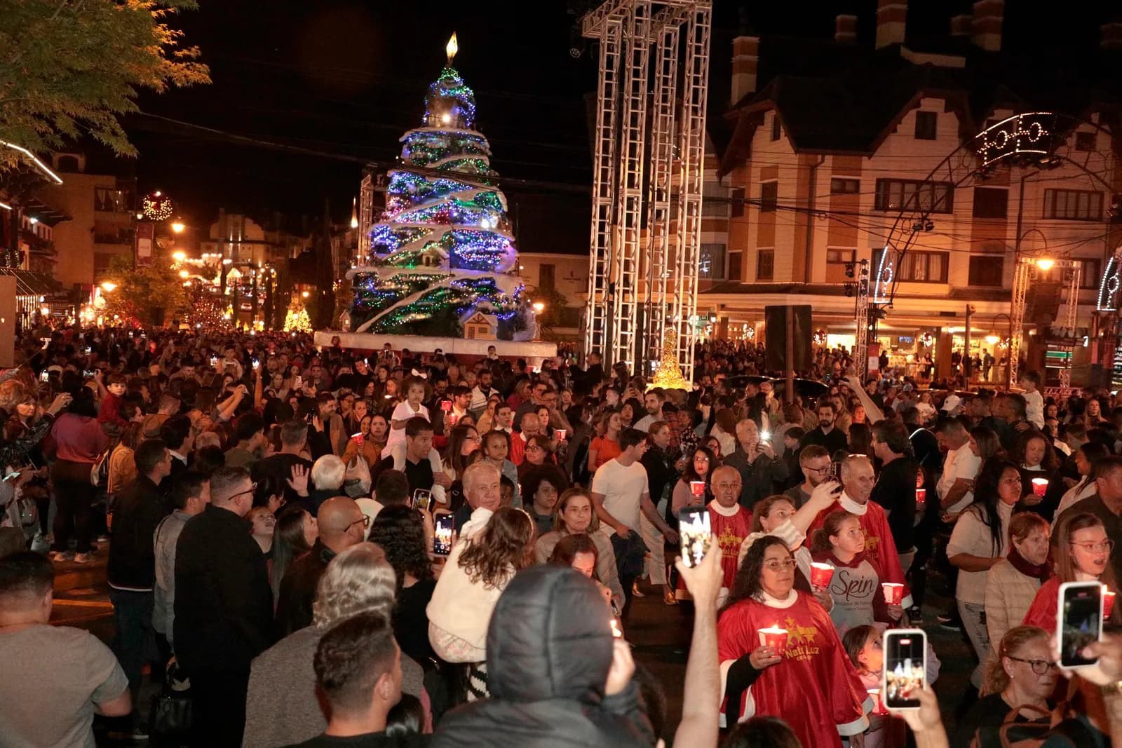 Multitud de noche frente a un árbol de Navidad iluminado en Gramado