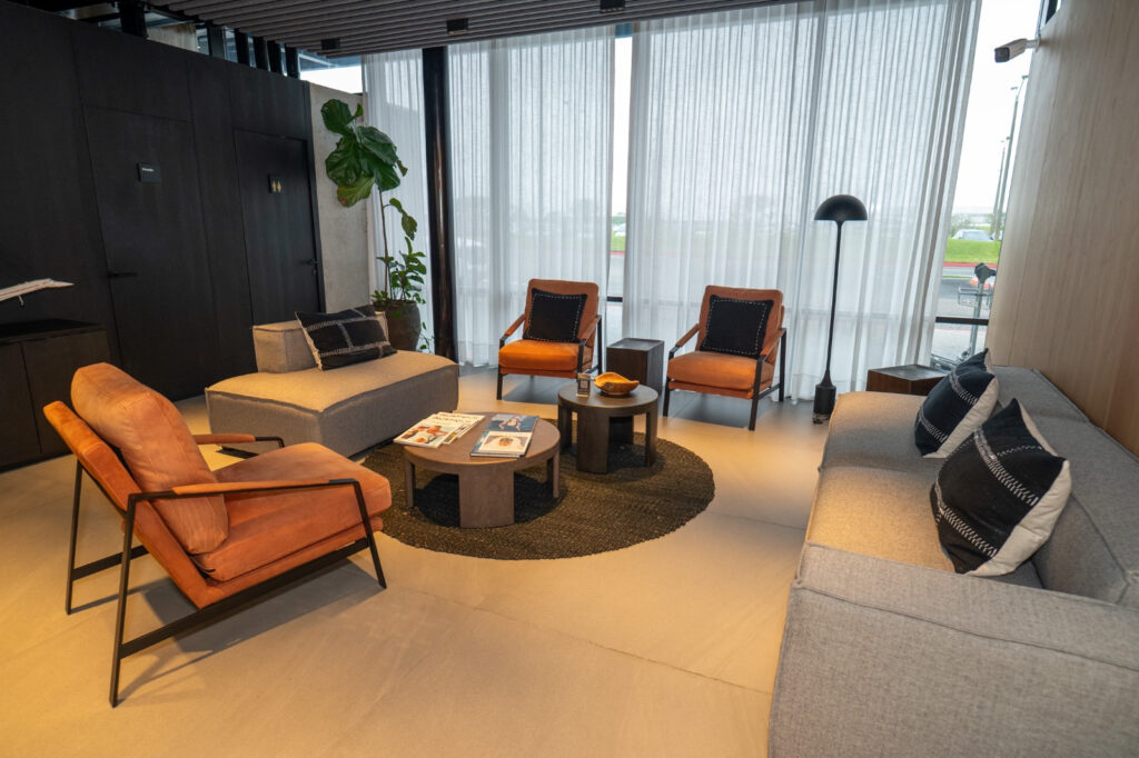 Sala de estar de la Terminal de Aviación Ejecutiva con sillones y ventanales