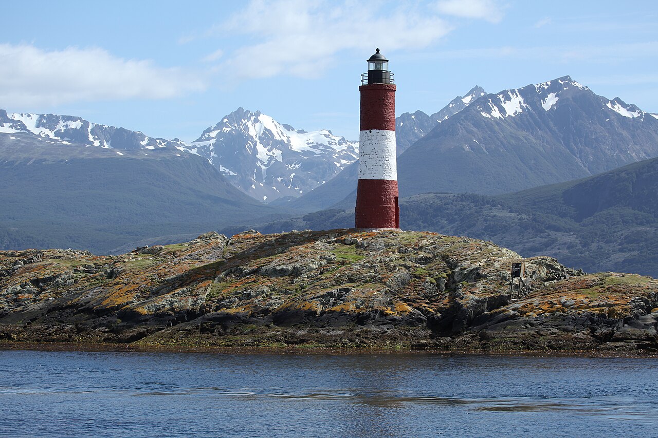 Faro Les Eclaireurs sobre un islote del Canal Beagle con montañas nevadas al fondo