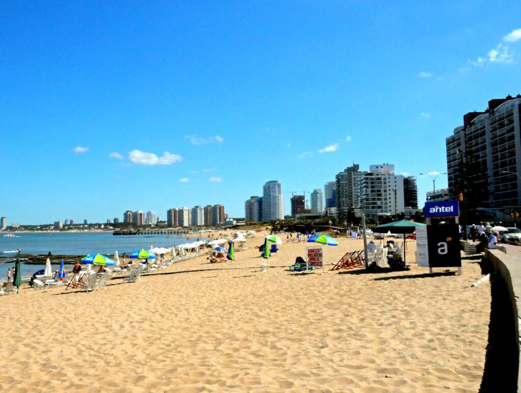 Playa de Punta del Este con sombrillas y edificios frente al mar en un día de verano
